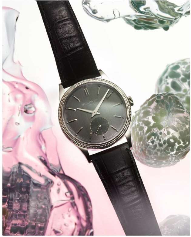 Elegant wristwatch with black leather strap displayed against a backdrop of abstract water droplets, suitable for luxury watch advertising.