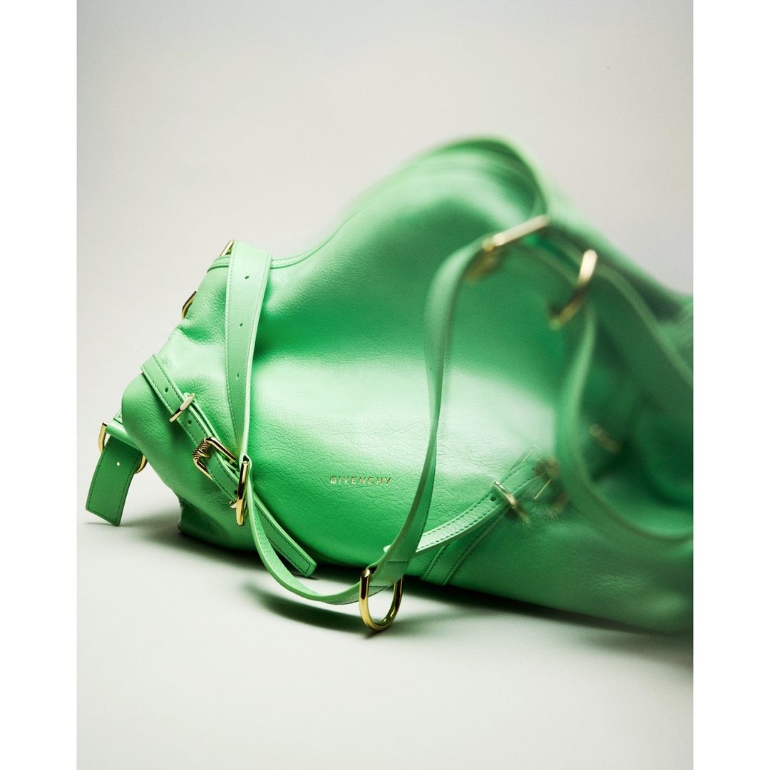 Mint green Givenchy handbag with leather texture, straps, gold hardware, and buckles, in a product studio shot.