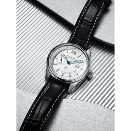 Close-up product photograph of a luxury mechanical watch with a white dial and black leather strap on a textured surface.