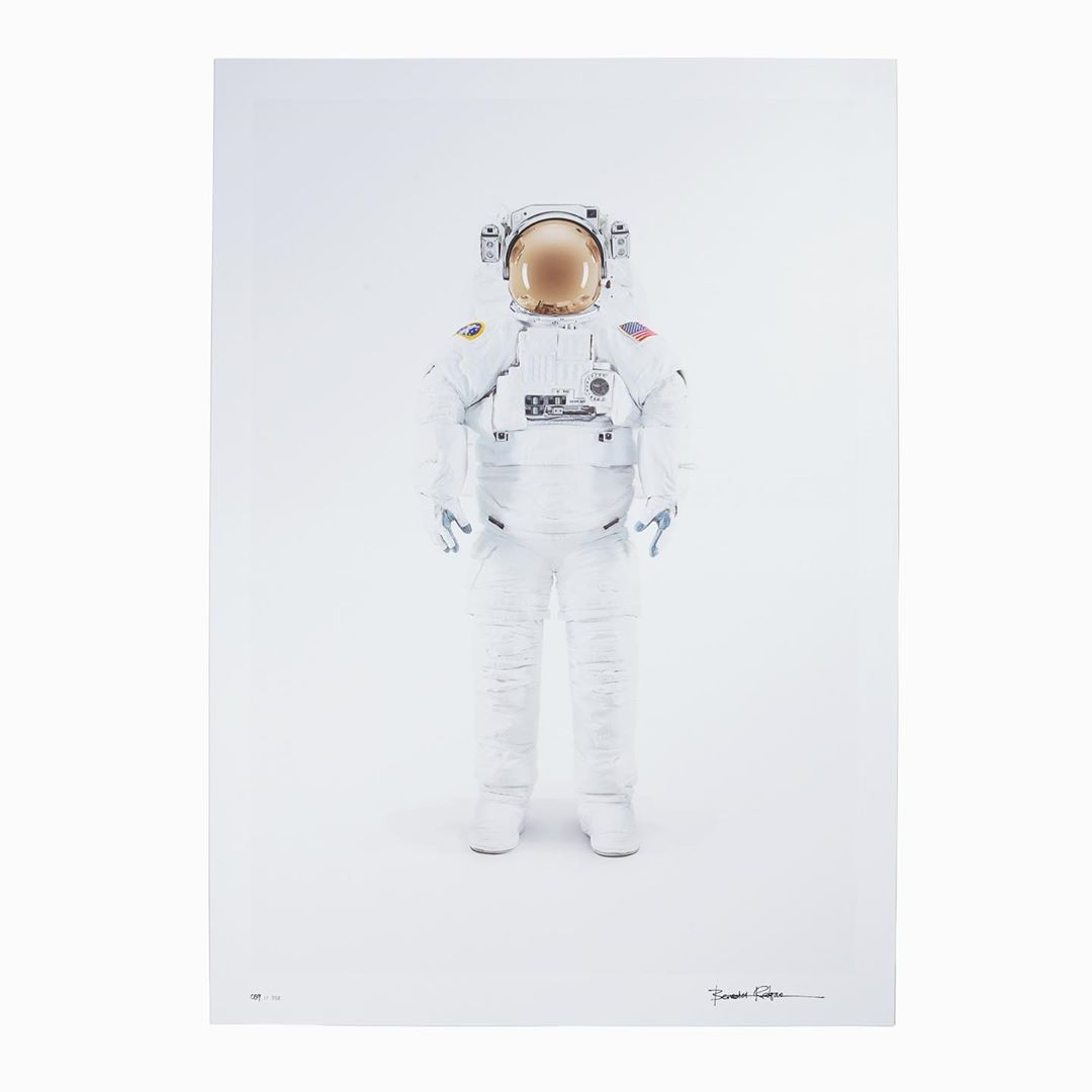 Full-length studio shot of an astronaut in a spacesuit against a white backdrop, featuring detailed suit textures and helmet reflection.