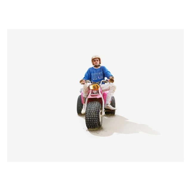 An adult rides a pink three-wheeled ATV on a bright white background, creating a minimalist image focused on transportation and recreation.