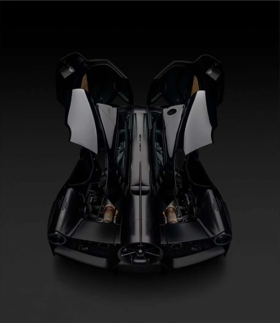 Sleek black car on a black surface shown in a studio shot from the front with its doors open for an interesting automobile product shot.