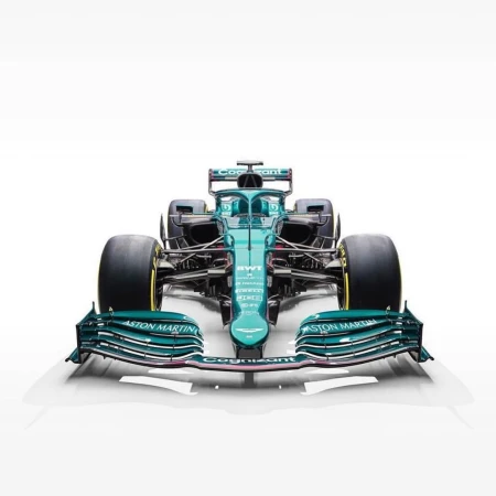 Front view of a green Aston Martin Formula 1 race car against a white background, showcasing its aerodynamic design and racing tires.