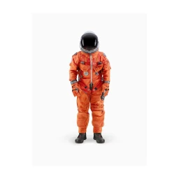 Full-length studio portrait of an astronaut wearing a bright orange spacesuit and dark helmet against a plain white background.
