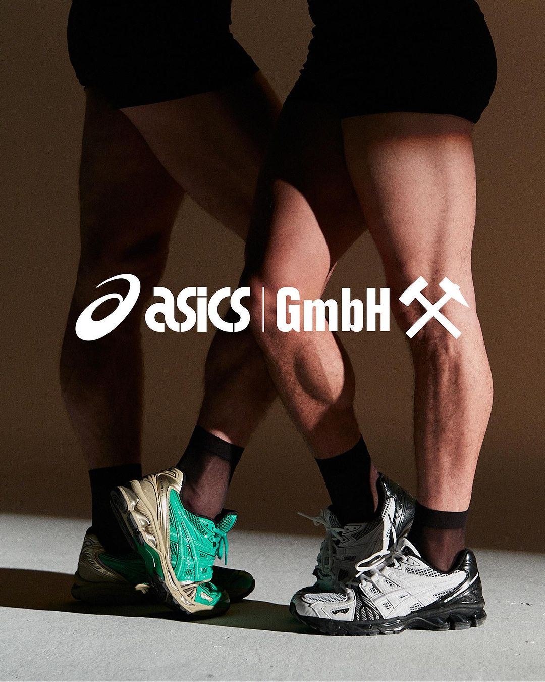 Two male models showcasing ASICS athletic shoes, wearing black socks and shorts against a neutral background, with the brand's logo displayed.