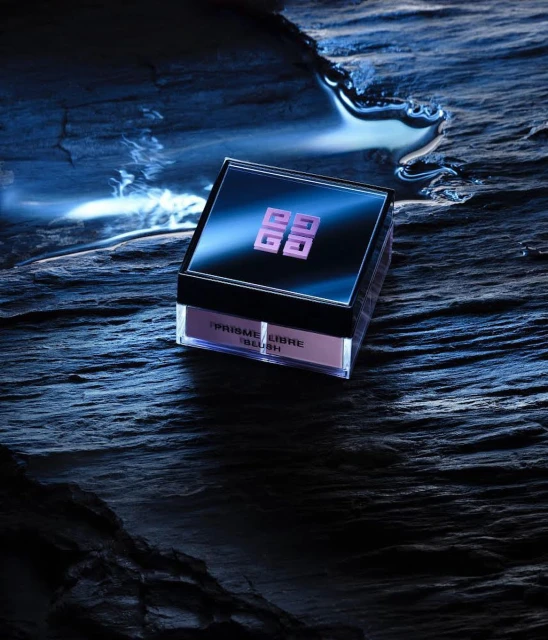 Givenchy Prisme Libre blush product shot. Makeup in box. Dramatic lighting with water and rough rocky texture for a beauty product.