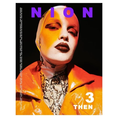 Fashion editorial shot of a woman in an orange coat and patterned scarf, featuring bold makeup and neon text overlay on a dark background.
