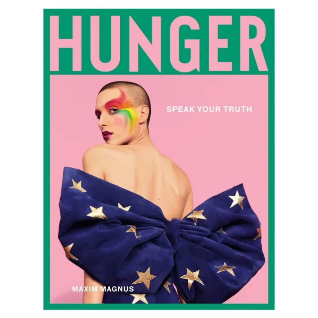 Magazine cover featuring a bare-backed person with rainbow eye makeup and a large blue bow with gold stars, against a pink and green background.