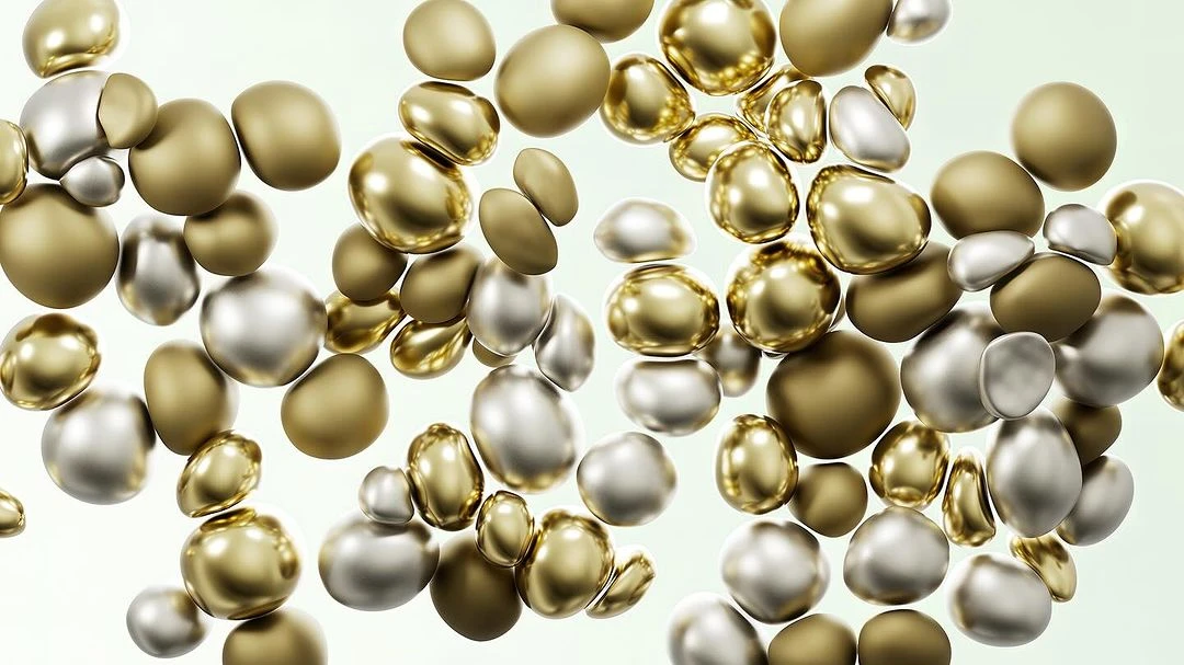 Abstract arrangement of golden and silver rounded pebbles with a reflective sheen against a light background, creating a modern art feel.