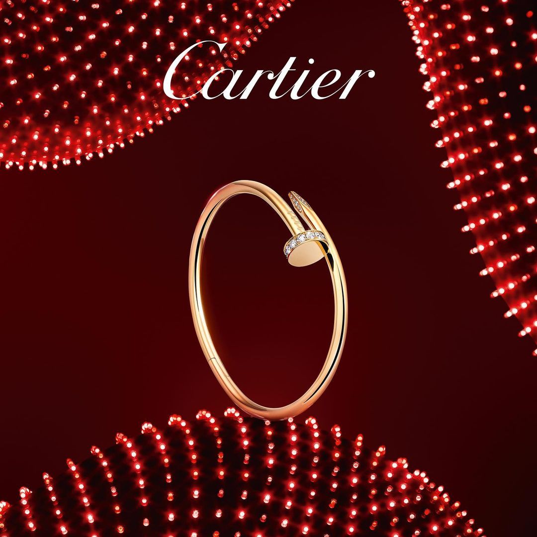 Elegant gold nail bracelet with diamonds on a red background with bokeh lights, luxurious and stylish, suitable for jewelry ads.