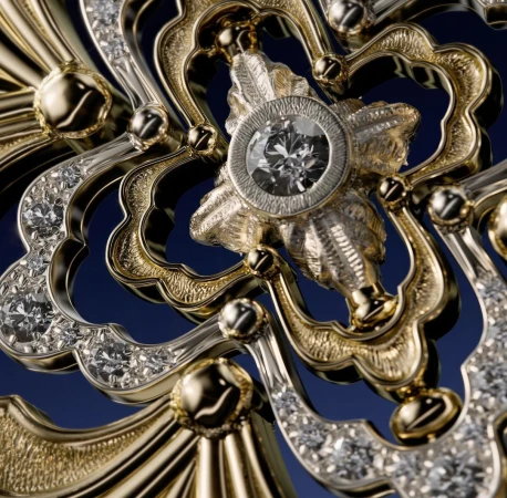 Ornate golden jewelry with diamond centerpiece on a dark blue background, showcasing intricate metalwork and craftsmanship.