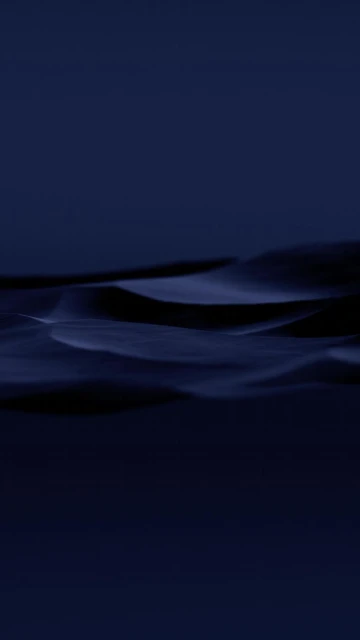 Abstract photograph of rolling, dark blue-toned dunes in a minimalist composition, evoking mystery and tranquility.