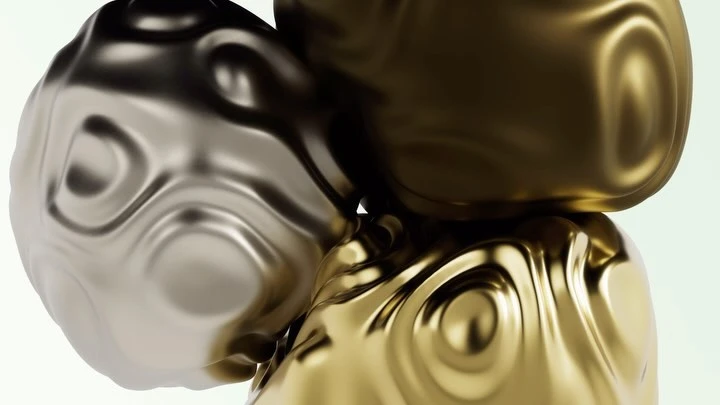 Abstract still life of three metallic spheres in shades of gold and silver, arranged on a white surface with studio lighting.