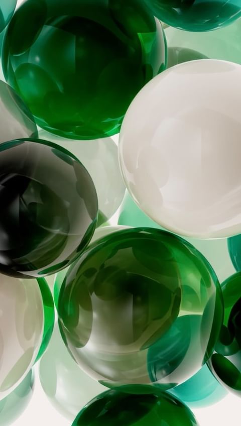 Abstract arrangement of green and white spheres creating a visually interesting and colorful background, showcasing depth and reflection.