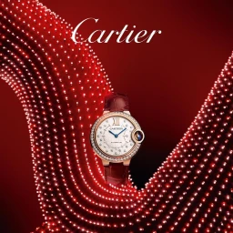 Cartier luxury watch with diamond bezel and red leather strap positioned centrally against a swirling red dotted background.
