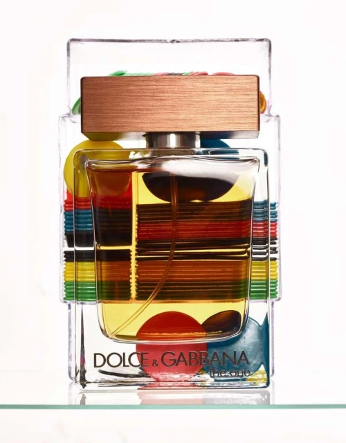 Dolce & Gabbana The One fragrance bottle on display with colorful accents and transparent packaging, showcasing the product's details.