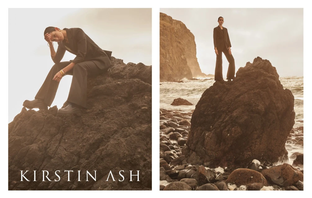Two fashion images of a person in a dark suit sitting and standing on rocks near the sea. Apparel brand campaign.