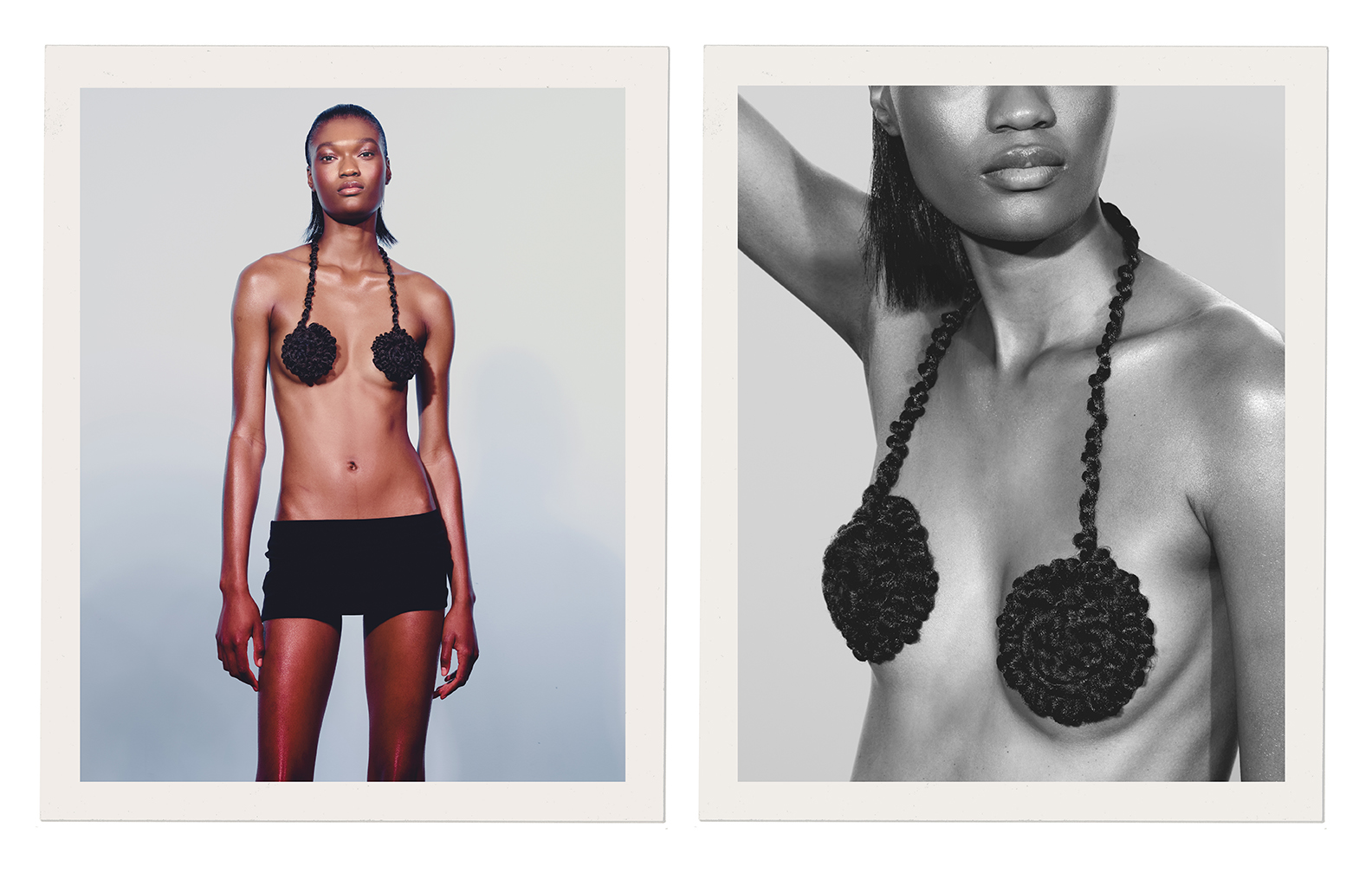 Studio shot of an African American fashion model wearing a black knit top and black shorts in a simple, stark setting. 
