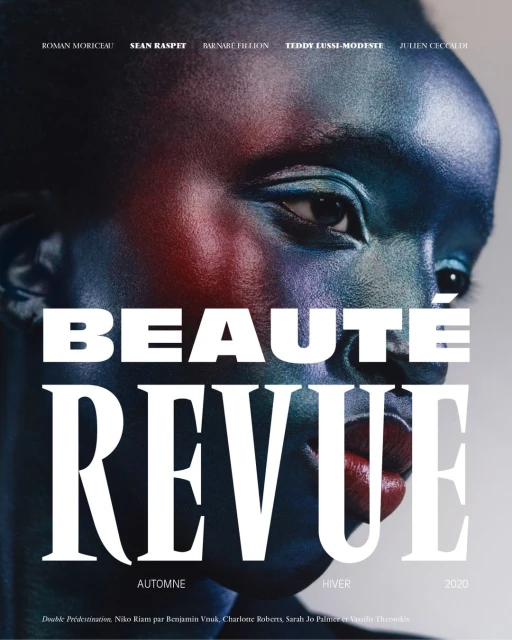 Dark-skinned model gazes in a beauty magazine cover shot with close-up framing, featuring multicolor face paint and bold typography.