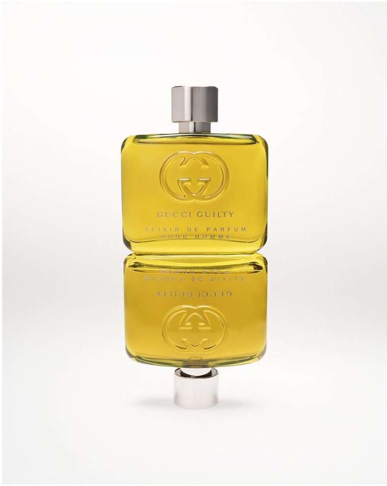 Still shot of a Gucci Guilty Elixir de Parfum bottle against a white background, featuring a square shape and a reflective surface.