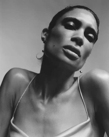Close-up portrait of a woman with short dark hair in a slip dress against a neutral studio background by Benjamin Vnuk