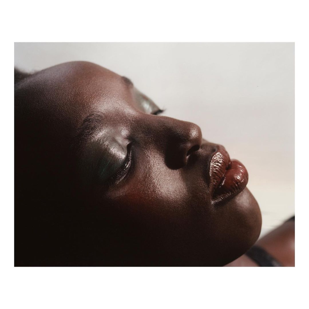 Close up profile portrait of a black woman with glossy brown lips and metallic eyeshadow photographed by Benjamin Vnuk
