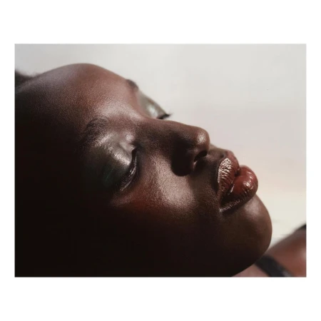 Close up profile portrait of a black woman with glossy brown lips and metallic eyeshadow photographed by Benjamin Vnuk