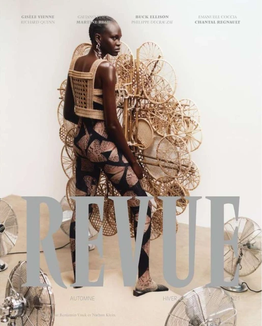 Fashion magazine cover featuring an African woman in a woven top and patterned leggings, surrounded by vintage fans, studio setting.