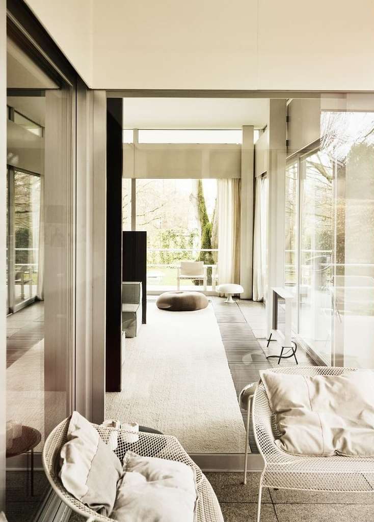 Modern living room featuring neutral tones, natural light, indoor plants, and contemporary furniture, creating a minimalist and serene atmosphere.
