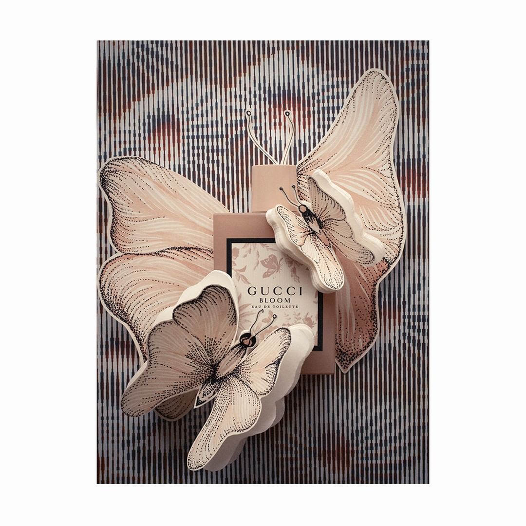 Gucci Bloom Eau de Toilette fragrance, soft color palette, butterfly accents, studio lighting, and sophisticated presentation.