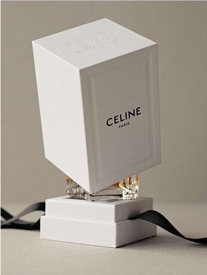 Elevated Celine perfume box on display with crystal accents, tied with black ribbon against a muted neutral backdrop in a studio setting.