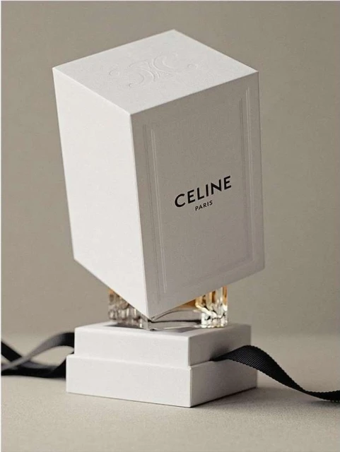 Elevated Celine perfume box on display with crystal accents, tied with black ribbon against a muted neutral backdrop in a studio setting.