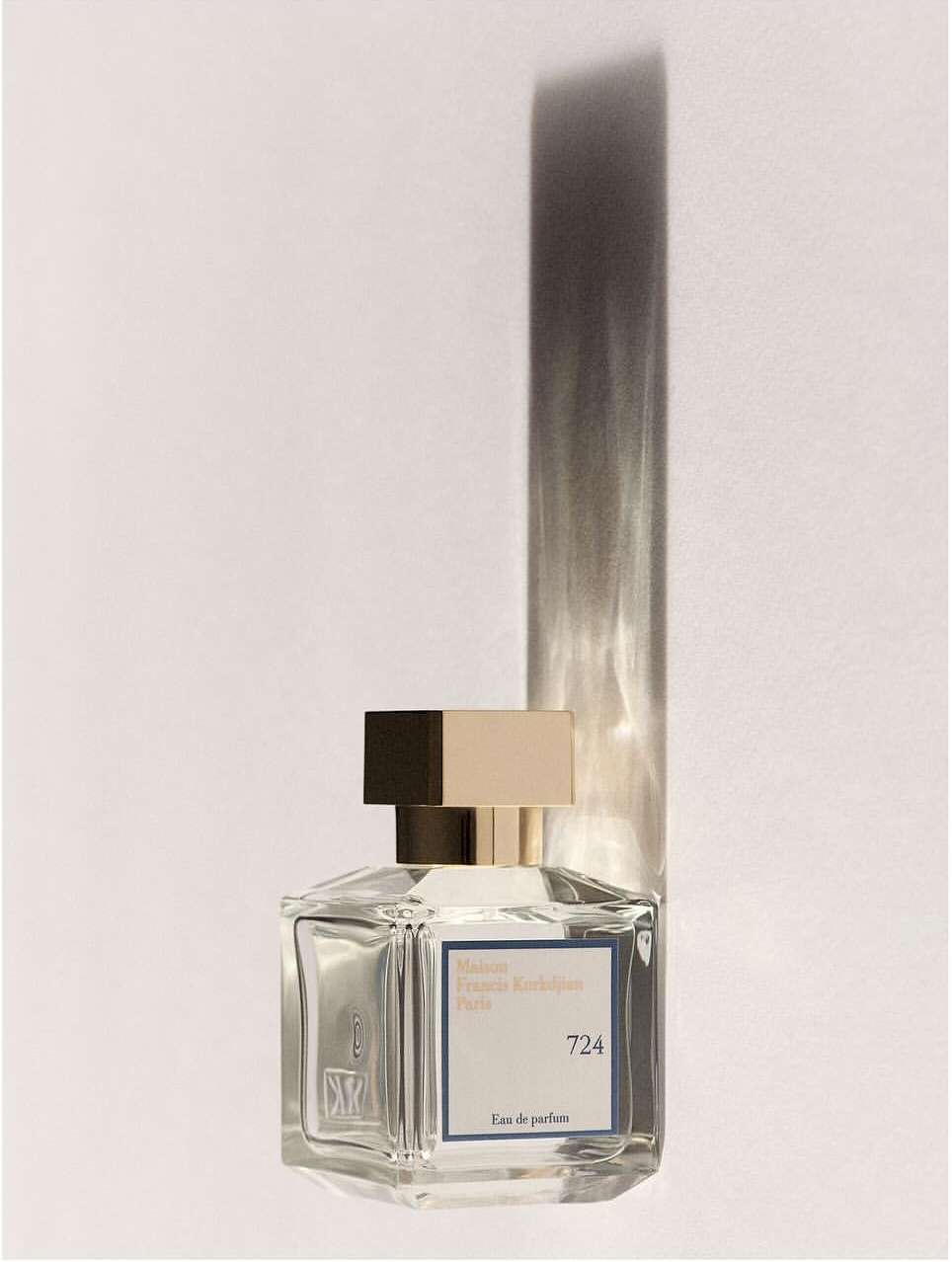 Baccarat Rouge 724 Paris eau de parfum bottle, light-toned background with a long vertical shadow cast to the right.