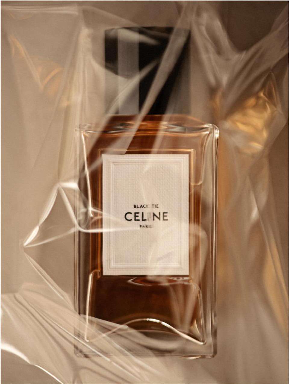 Celine Black Tie perfume bottle in clear packaging. Amber liquid inside a square glass bottle with a black cap and label.