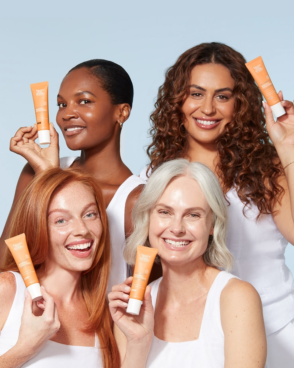 Diverse group of smiling women holding beauty product tubes. A vibrant image for beauty, skincare, and inclusive marketing.