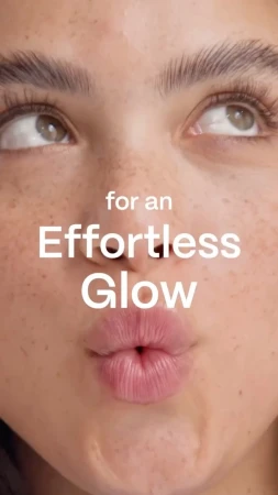 Extreme close-up beauty portrait of a woman with freckles puckering her lips and looking up, featuring superimposed text.