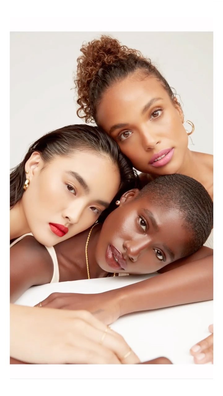 Three female models with diverse ethnicities posing closely together against a plain white background by Beth Sternbaum