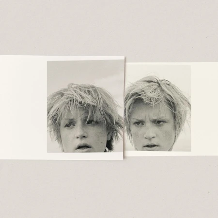 Two overlapping black and white photographic prints featuring close-ups of a young person with tousled hair against a plain background