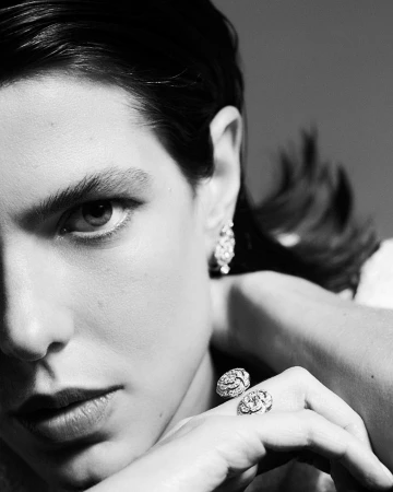 Close-up portrait of a woman wearing diamond earrings and ornate rings photographed by Betina Du Toit.