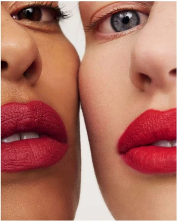 Close-up portrait of two women wearing vibrant red lipstick against a plain white background by Betina Du Toit