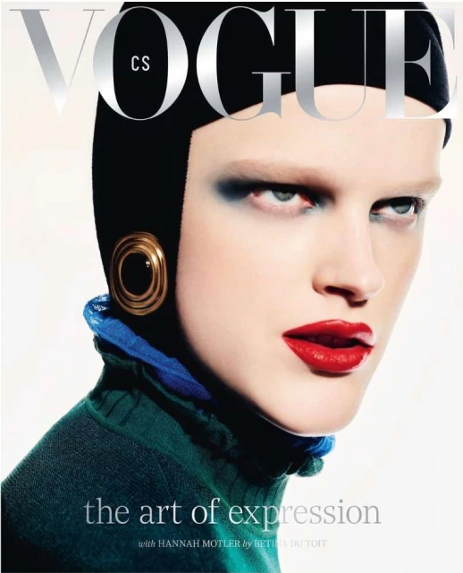 Vogue cover featuring a model with bright makeup, wearing a black cap and green top, against a clean white backdrop.