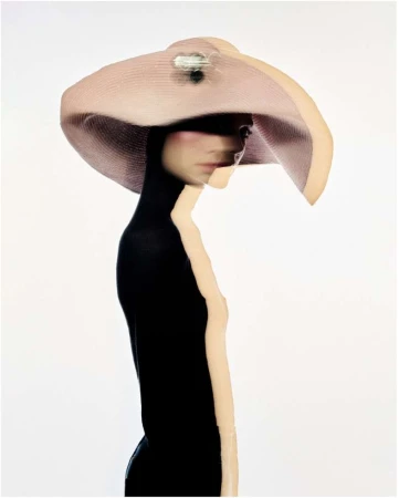 Surreal fashion portrait by Betina Du Toit featuring a person wearing a wide-brimmed pink hat against a plain white background