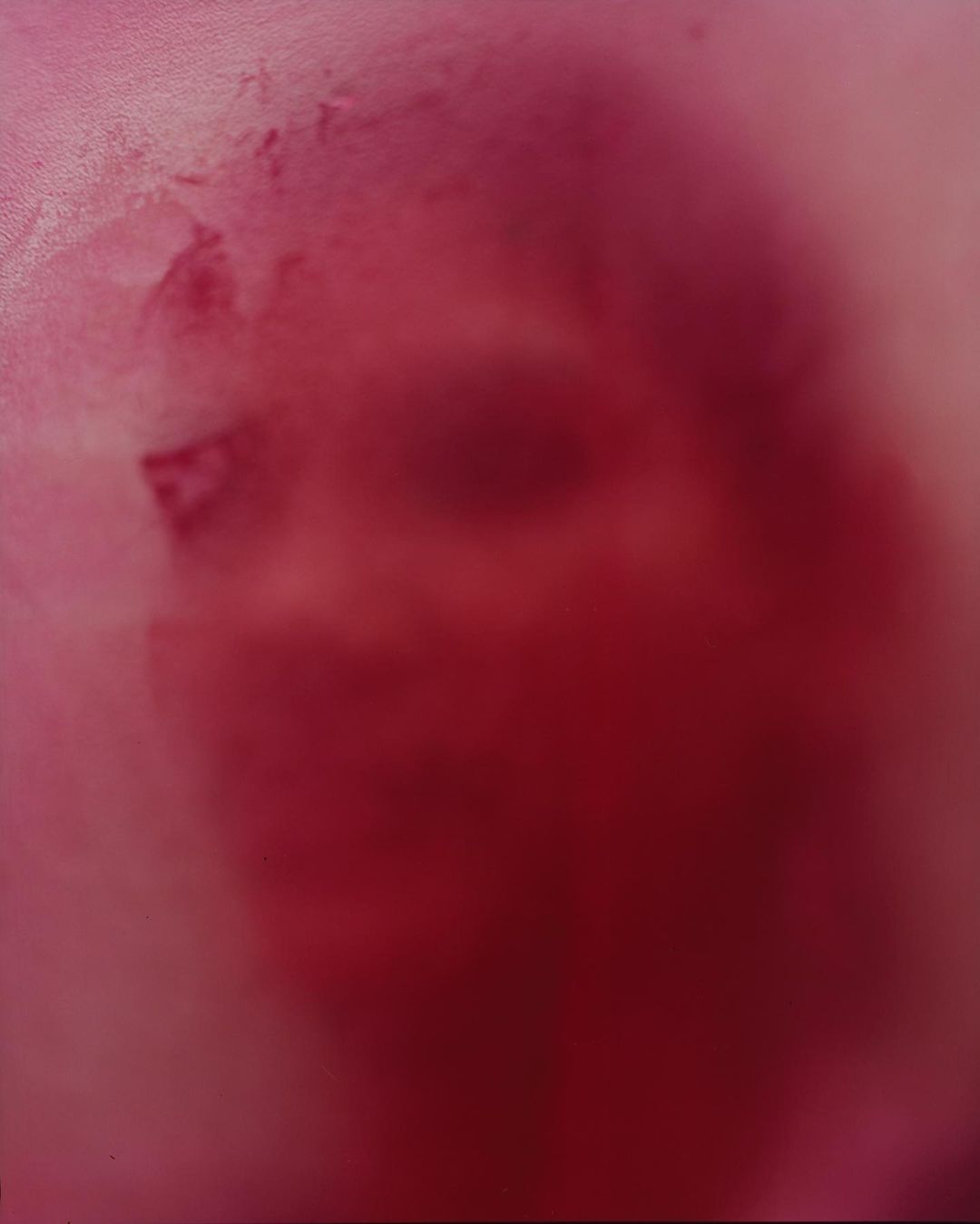 Abstract painting featuring blended tones of pink, red, and white, creating a soft, dreamy effect on a textured surface.