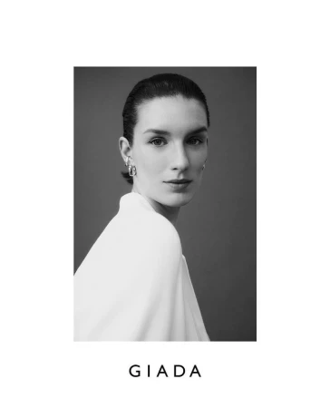 Black and white portrait of a woman wearing silver hoop earrings and a white top by photographer Bibi Cornejo Borthwick