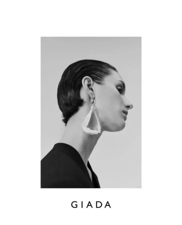 Black and white profile portrait of a woman wearing statement sculptural earrings and a dark top by Bibi Cornejo Borthwick