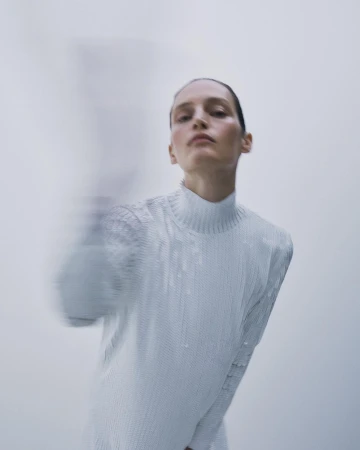 Model in a textured white mock-neck top with motion blur by photographer Bibi Cornejo Borthwick