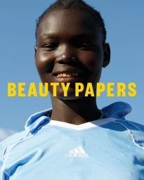 Portrait of smiling young Black woman wearing a light blue sports jersey against a clear blue sky