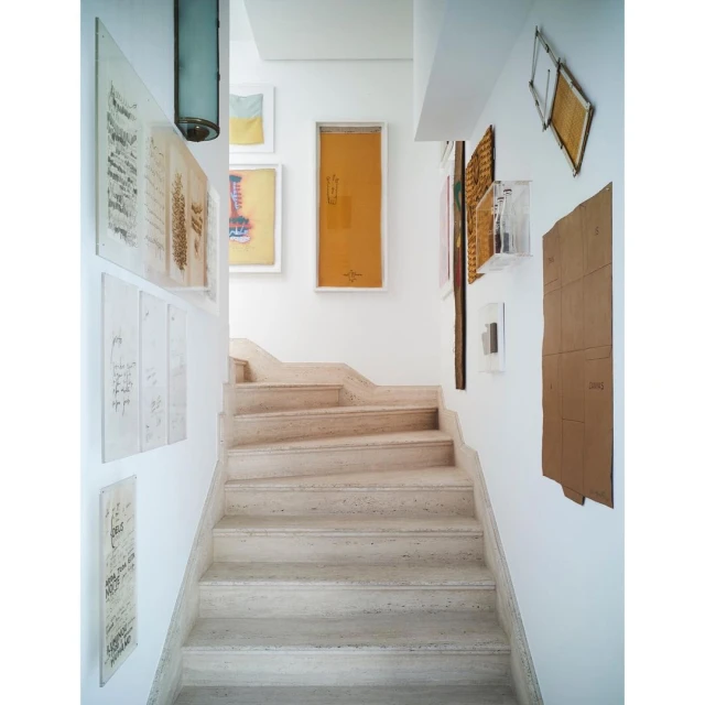 Interior view of a staircase in a home with art hanging on the walls, bathed in natural light, creating a bright and inviting space.