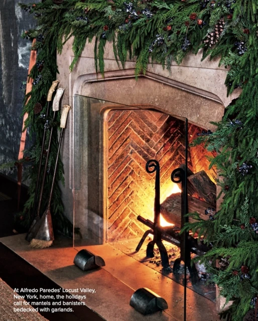 Stone fireplace decorated with green garland and pinecones in a home interior setting, creating a cozy, festive, and warm ambiance.