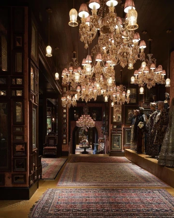 Luxurious interior with ornate crystal chandeliers, oriental rugs, and wall displays photographed by Bjorn Wallander.